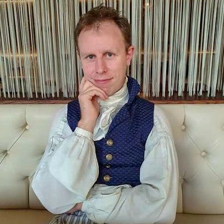 Richard Hiatt aka @coatandbreeches on Instagram adorning a Regency attire in a restaurant