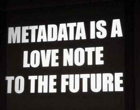 Black sign with white text in block letters reading: “Metadata is a love note to the future”