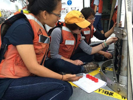 Hannah Bourne teaches Xiao Fu and YiZhuang Liu check the sensors on the CTD before deployment. (Photo: Sarah Yang)