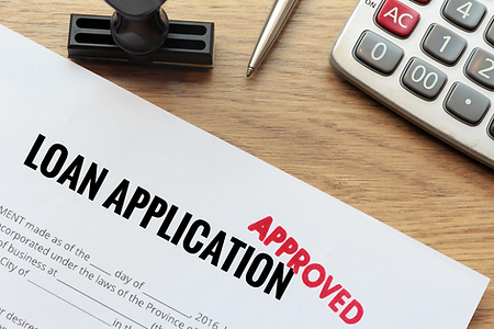 Picture of a Loan application with the word, Approved, stamped in red on it