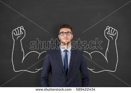 Businessman in front of chalkboard with muscular arms drawn in