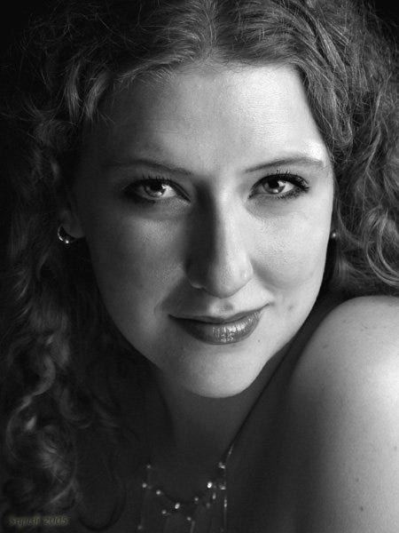 A glamorous black and white photo of a woman with curly hair