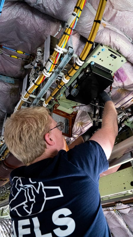 An AELS team member removing components from a plane to ready for disassembly