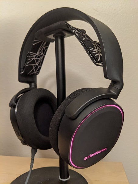 Side view of the Arctis 5 Headset with pink lights around the edge.