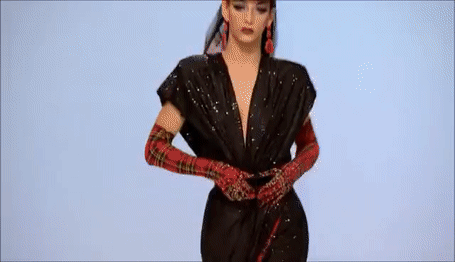 GIF: Drag queen Violet Chachki on RuPaul’s Drag Race walking a runway and revealing a red garment from under a black one
