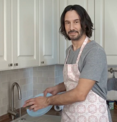 AI-generated image of Keanu Reeves washing dishes in a pink apron.