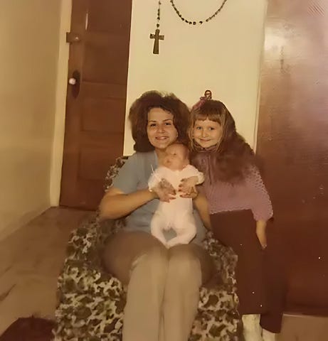 Mom holding me on her lap with my sister next to us