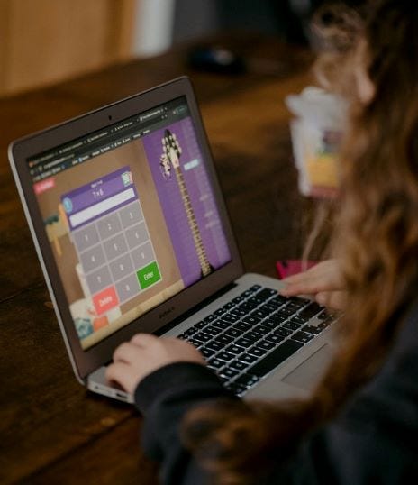 A young girl on her computer works on a math problem at home.