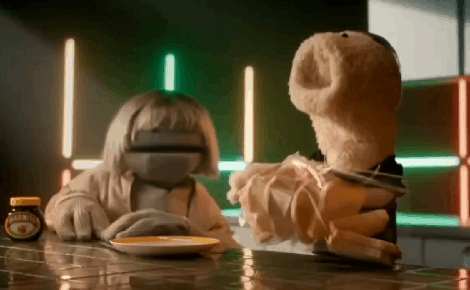 A GIF of a puppet looking over-excited whilst handling bread