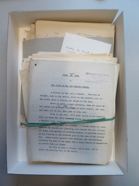 A birds eye view of a stack of archival documents banded together in an open box