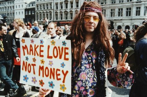 Hippie man in the 1960s, holding ‘Make Love Not Money’ sign