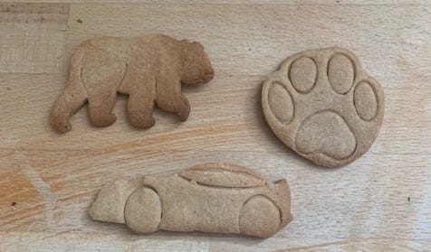 Three ginger biscuits in the shape of a bear, a paw print, and a racing car