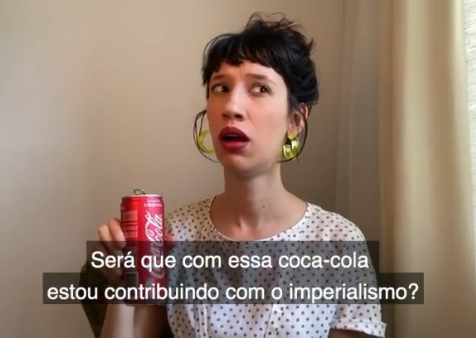 A personagem de Tina com uma lata de coca-cola na mão, preocupada. A legenda diz: “Será que com essa coca-cola estou contribuindo com o imperialismo?”.