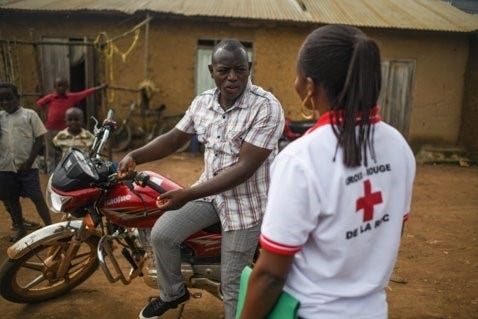 A motorcyclist and a Red Cross member of staff speaking.