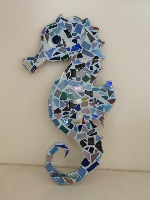 Photo of a seahorse mosaic, filled with blue and green glass tiles