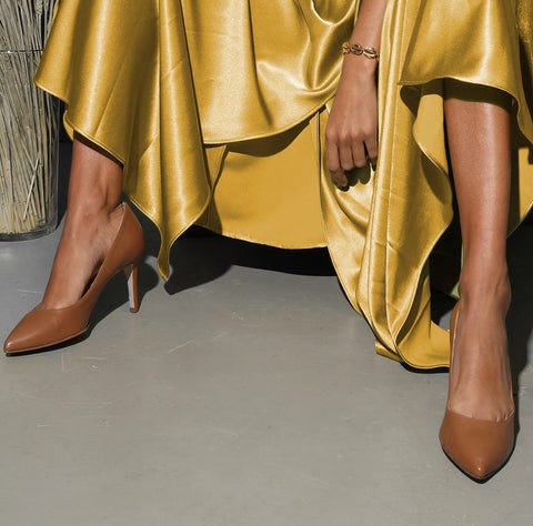 Shot of legs in brown pump shoes and yellow dress