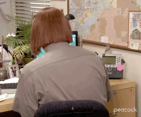 Personagem Dwight da série The Office virando para a câmera usando uma peruca ruiva demonstrando seriedade
