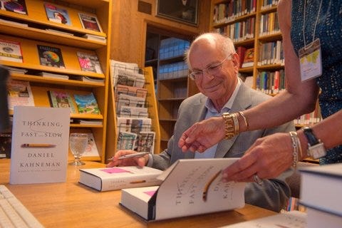 Daniel Kahneman signing copies of “Thinking, Fast and Slow” in CASBS’s library reading room in 2013. [CASBS files]
