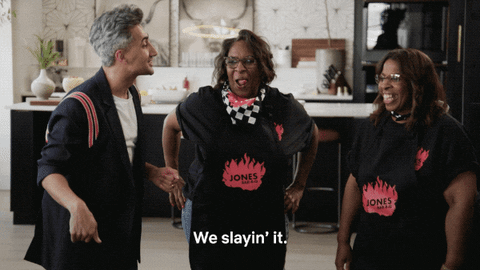Moving image of Tan France of Queer Eye alongside two participants of the show, gesturing with a caption ‘We slayin’ it’.