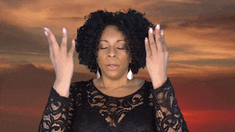 African american woman making a gesture with both of her hands to relax, breathe, and calm down