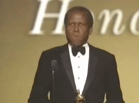 A tuxedo-clad Sidney Poitier putting his hand over his chest and breathing a sigh of relief as he accepts his honorary Academy Award.