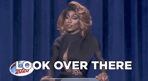 GIF of RuPaul’s drag race where a host says “look over there” distracting others