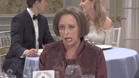 Debbie Downer from SNL sitting at a dinner table with the caption “Not buying it”