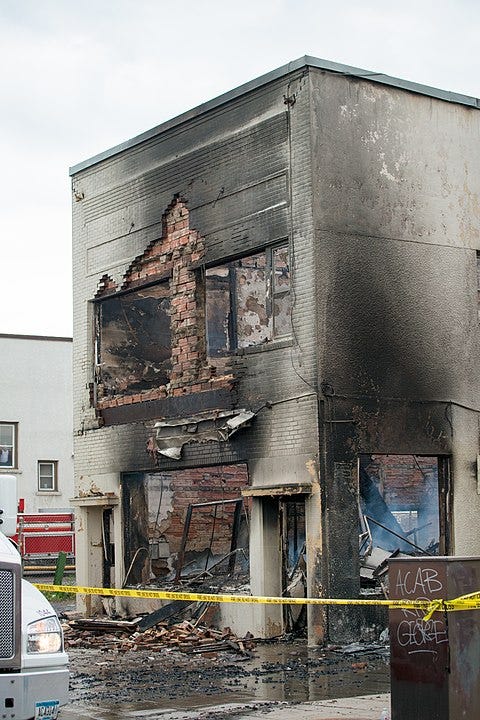 Minnesota, USA — Protest and riot aftermath on East Lake Street. Burned brick building, tardis shaped.