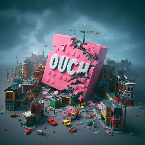 A dilapidated city made of lego with a giant dystopian pink block reading ‘Ouch’