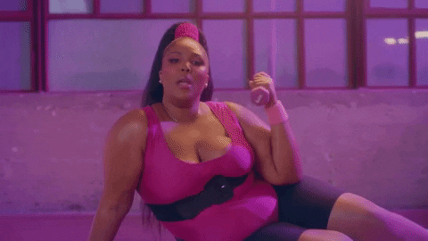 Image description: Gif of artist Lizzo lifting a dumbbell in workout clothes from her film clip ‘Juice’