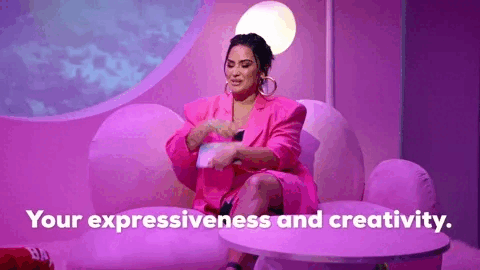 An animated GIF of a lady in a pink blazer sitting on a purple chair behind a purple table with a purple wall behind her with text that says, “Your expressiveness and creativity.”
