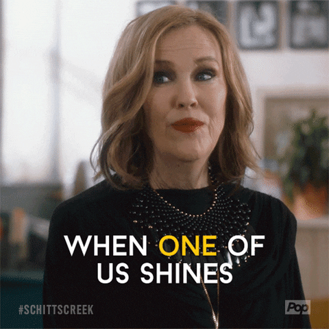 A gif from Moira of Schitt’s Creek saying “When one of us shines, all of us shine.”