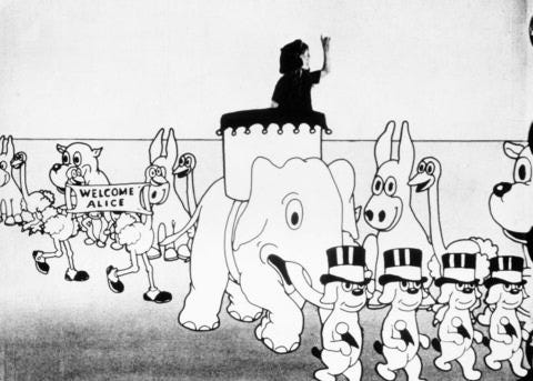 A still frame from Disney’s “Alice’s Wonderland” short film with a real girl riding atop a cartoon elephant in a parade of other cartoon animals