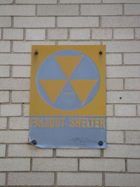 Fallout shelter sign on exterior of building.