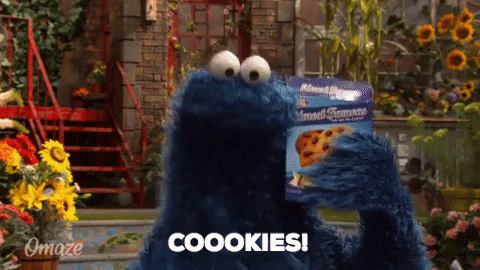 GIF of Cookie Monster, Sesamese Street character, holding a box of cookies and yelling “Cookies!”
