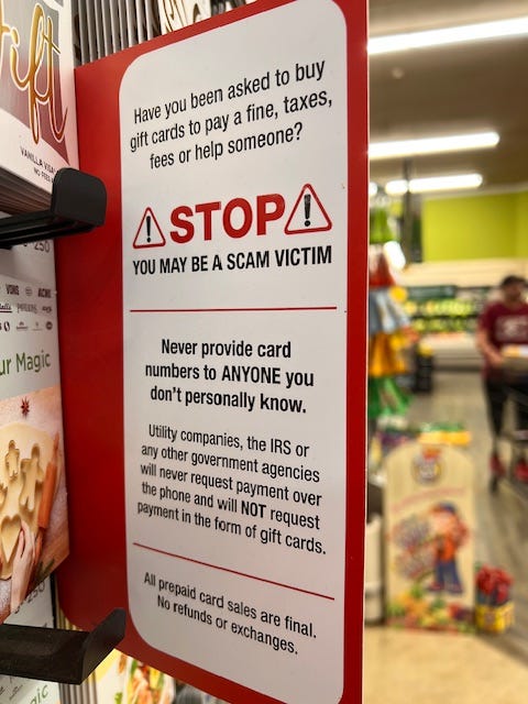 Sign at grocery store warning gift card purchasers to be aware of scammers