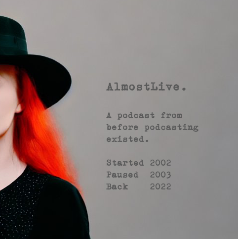 This is the current cover of my new, old podcast, “AlmostLive.” For clarity, the name is always CamelCase and ends with a period. The image is a grey background with a partial shot of a woman wearing a black fedora and red hair past and behind her shoulder. No features of the face are visible. The woman is wearing a longsleeve top with small, barely visible sparkles along the torso.