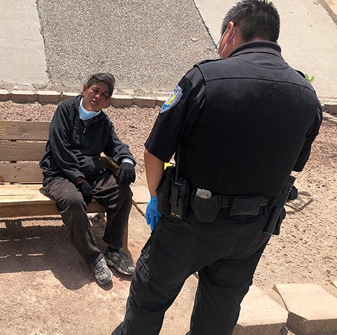 Gallup Police Officer J. Soseeah checks on the health of a woman in Gallup, New Mexico. Photo by Morgan Lee/AP Images