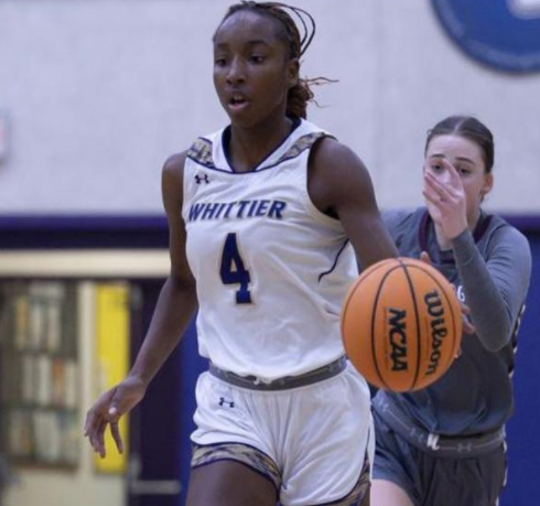 Image of Rhe Nae Leach dribbling a basketball, wearing her Whittier College basketball jersey.