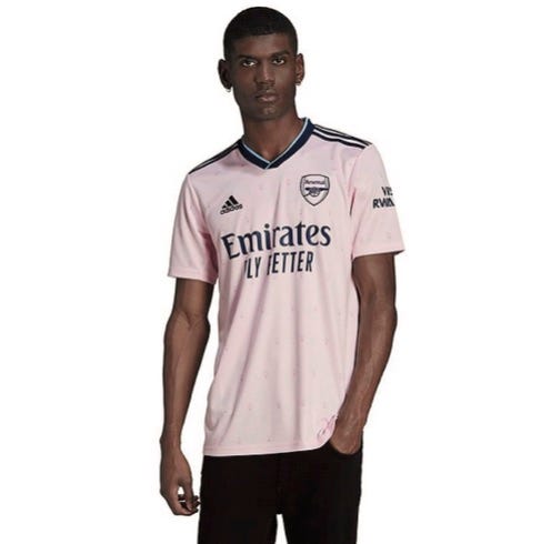 photo of man posing in pink Arsenal FC top