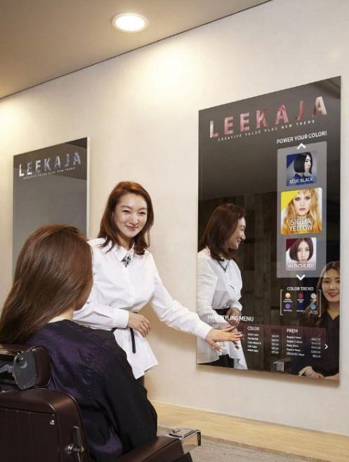 A hair salon in South Korea where the hairdresser is consulting the client for haircut selection using the Samsung mirror display