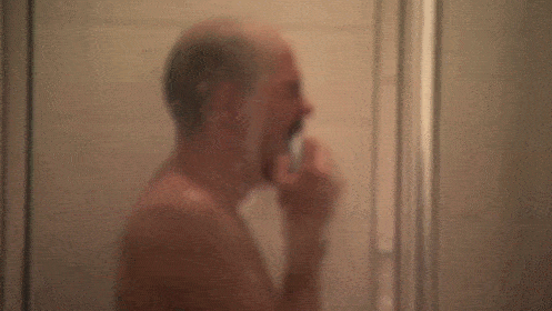 Bald man sobbing in the shower