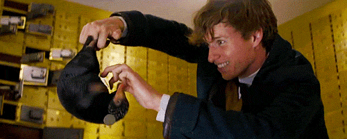 Scene from Fantastic Beasts and Where to Find Them, Newt Scamander tickles his niffler to release all the gold and jewels.