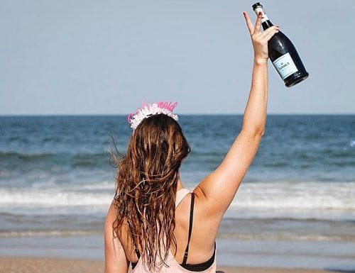 bachelorette party drinking games future bride at the beach with champagne