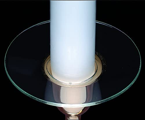 A clear glass circular bobeche with a white candle sitting in it.
