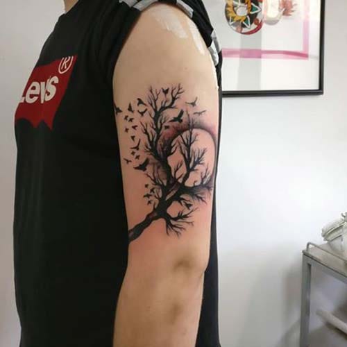 man upper arm tree tattoo