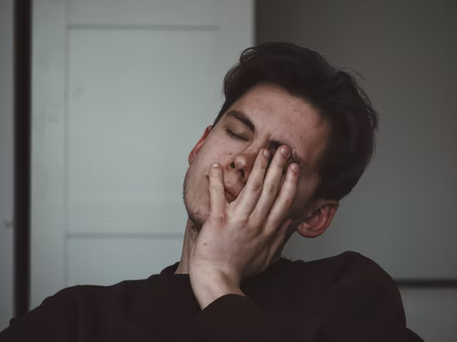 A man resting his face on his hand.