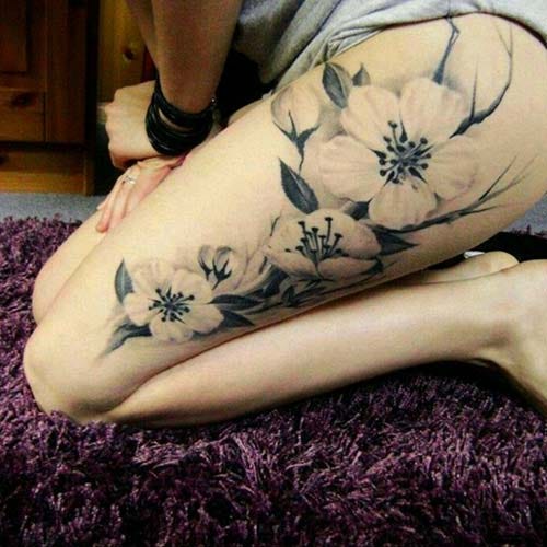 female upper leg flowers tattoos