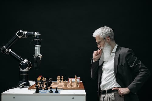 Un homme qui joue aux échecs contre un robot contrôlé par l’intelligence artificielle.