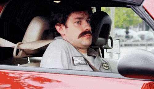 Jim Halpert of the office wearing a disguise, leaning back slowly in a car seat until he disappears behind the car door.